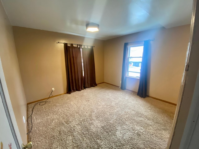 carpeted empty room with baseboards