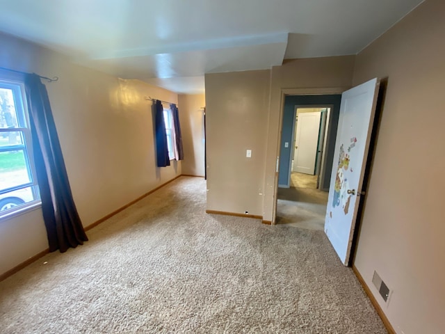 carpeted empty room with baseboards and plenty of natural light
