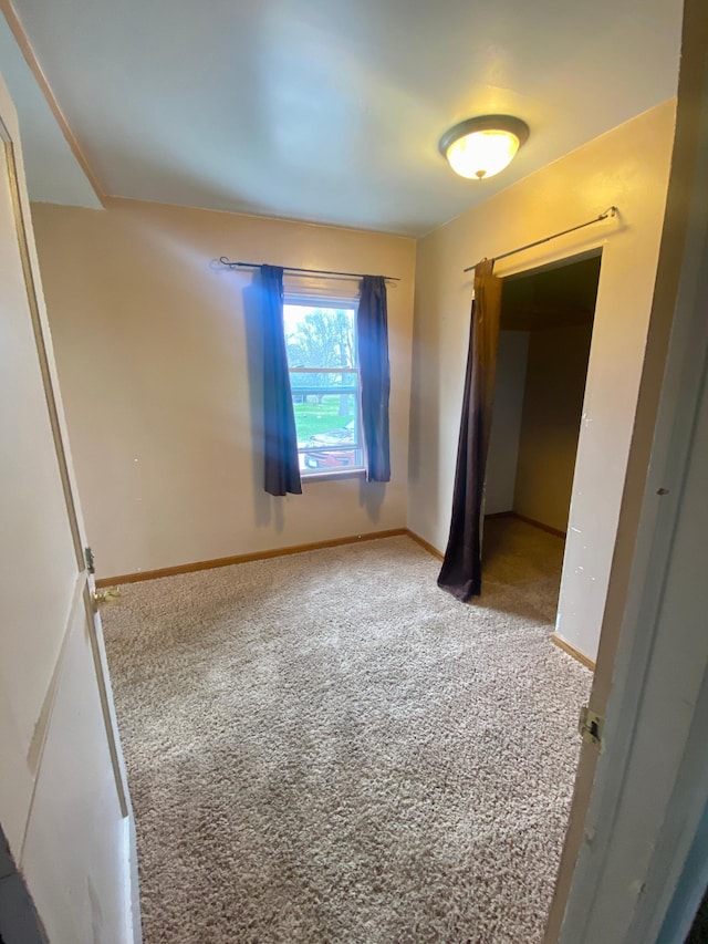 unfurnished bedroom with carpet flooring and baseboards