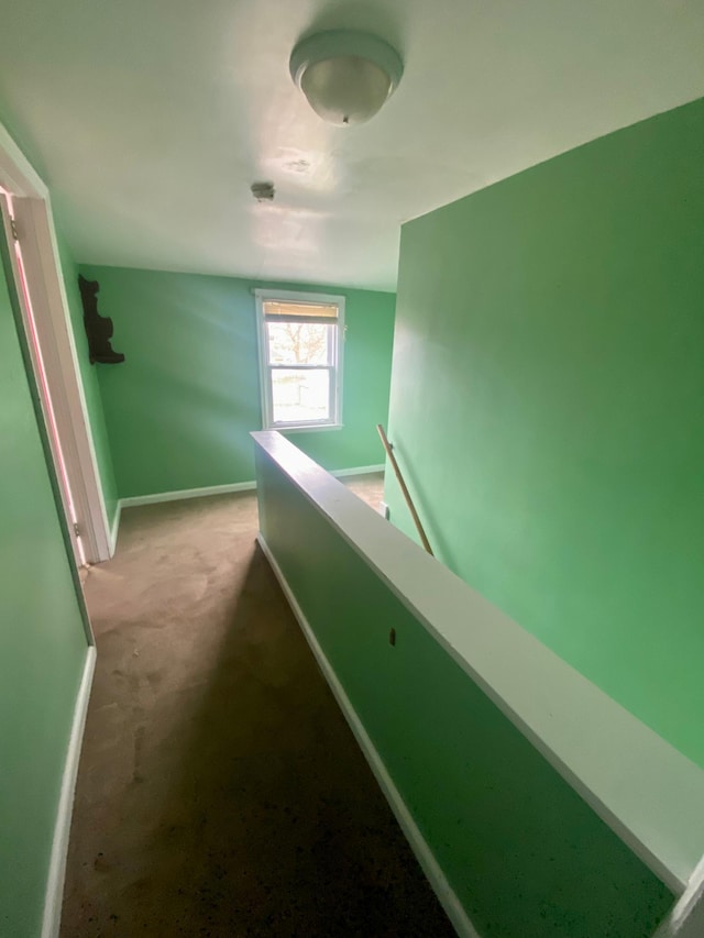 hallway featuring an upstairs landing, carpet, and baseboards