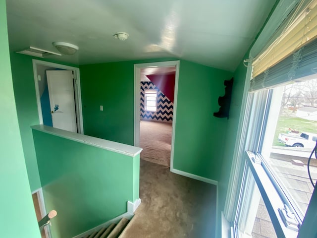 corridor with lofted ceiling and carpet flooring