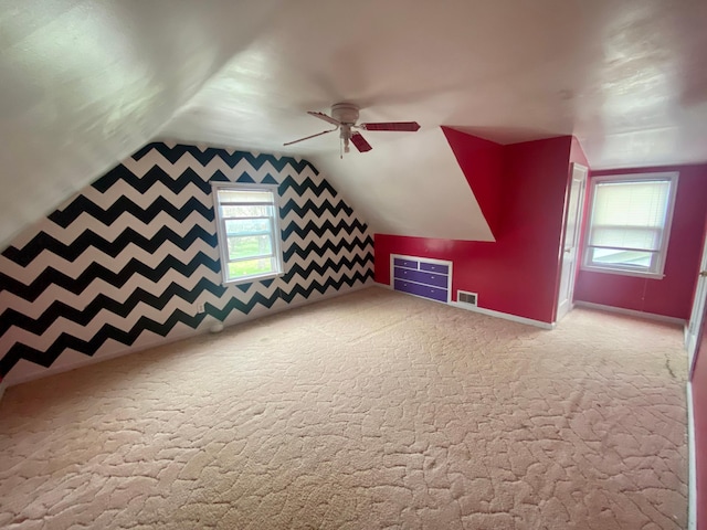 bonus room with visible vents, a healthy amount of sunlight, lofted ceiling, and ceiling fan