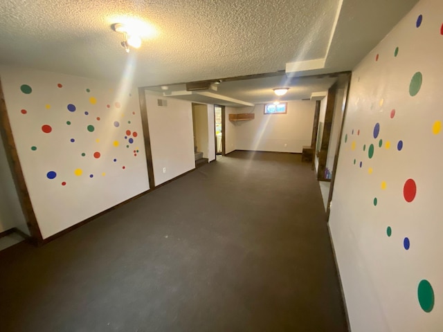 basement featuring a textured ceiling, visible vents, and stairs