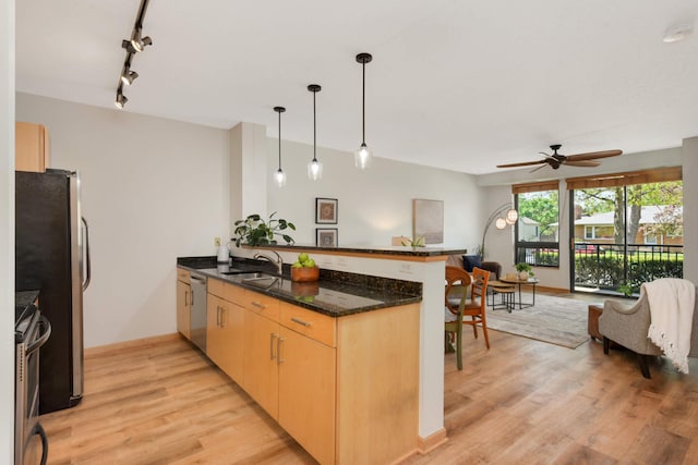 kitchen featuring a peninsula, appliances with stainless steel finishes, open floor plan, light brown cabinetry, and ceiling fan