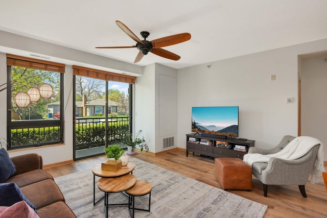 living room featuring a ceiling fan, wood finished floors, and baseboards