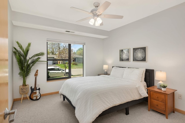 bedroom featuring baseboards, light colored carpet, and ceiling fan