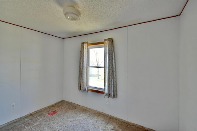 carpeted empty room featuring a textured ceiling