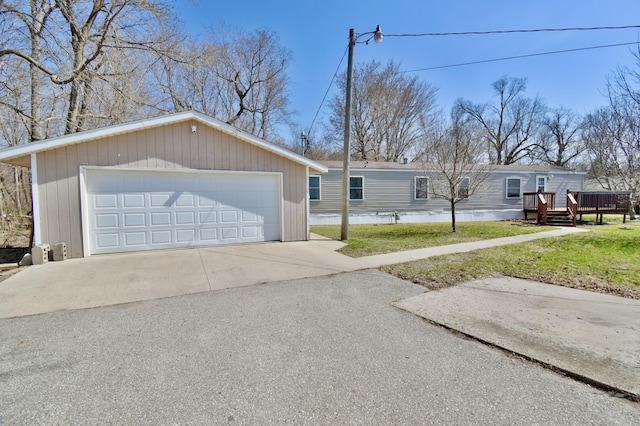 view of front facade featuring a front yard, an outbuilding, a deck, and a garage