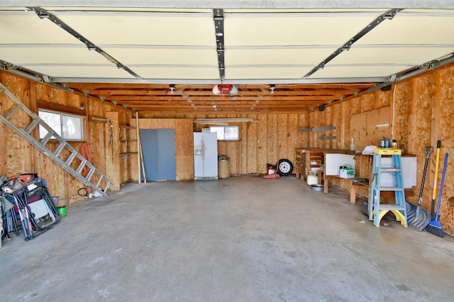 garage featuring white refrigerator with ice dispenser