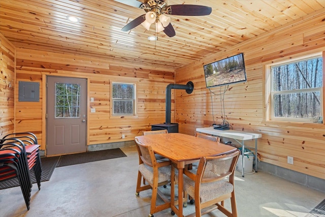 8494 Peary Junction Rd, Kelsey, MN 55724 - dining area featuring a wood stove, ceiling fan, wooden walls, electric panel, and wooden ceiling
