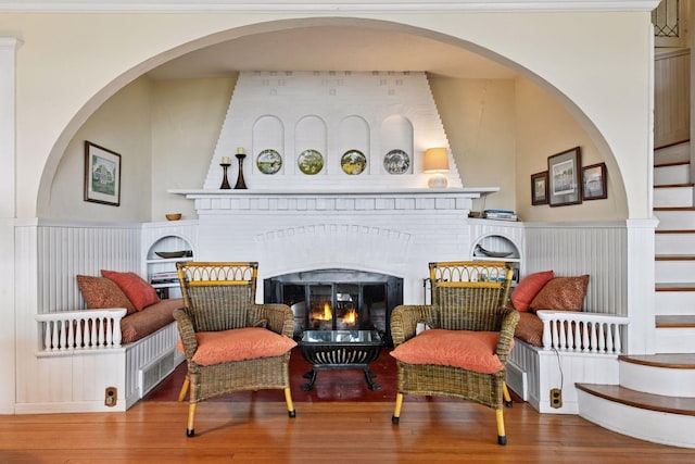 sitting room with a brick fireplace and wood finished floors