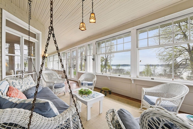 sunroom with a water view, wood finished floors, and outdoor lounge area