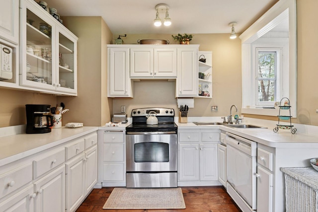 kitchen with stainless steel electric range oven, a sink, dishwasher, white cabinetry, and glass insert cabinets