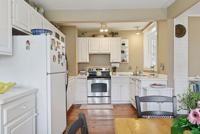 kitchen with light countertops, wood finished floors, white cabinets, and white appliances