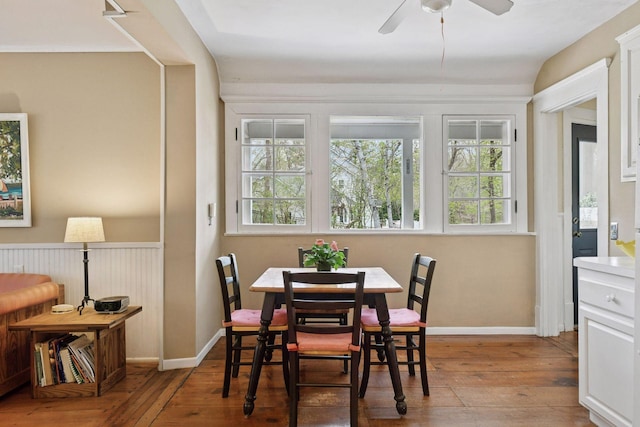 dining area with baseboards, ceiling fan, and wood-type flooring