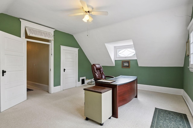 carpeted office space featuring baseboards, ceiling fan, and vaulted ceiling