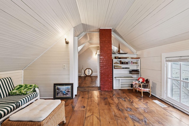 additional living space with wooden walls, vaulted ceiling, wooden ceiling, and wood-type flooring
