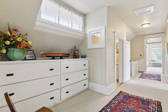 hallway with light carpet and lofted ceiling