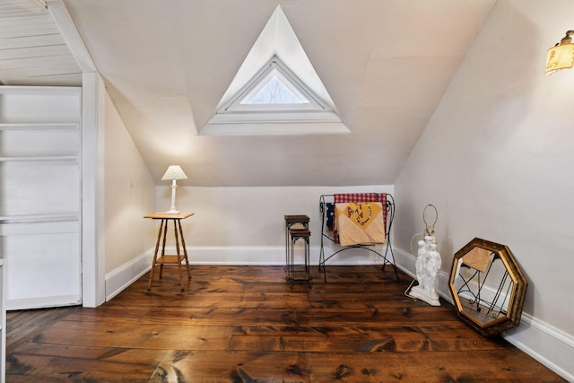 living area featuring baseboards, wood-type flooring, and lofted ceiling