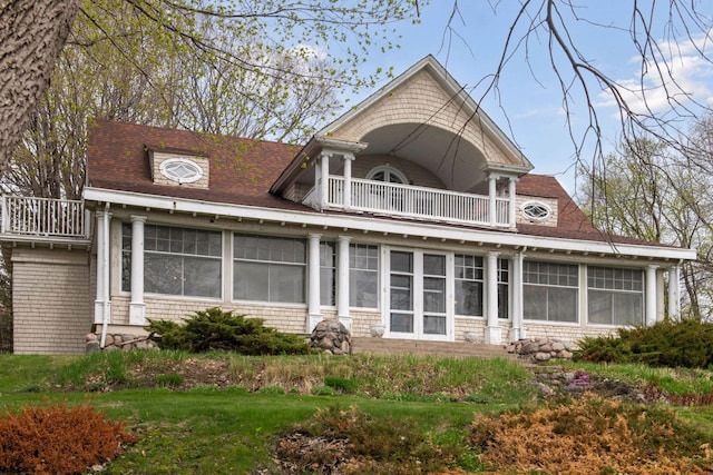 back of property with a balcony and a sunroom