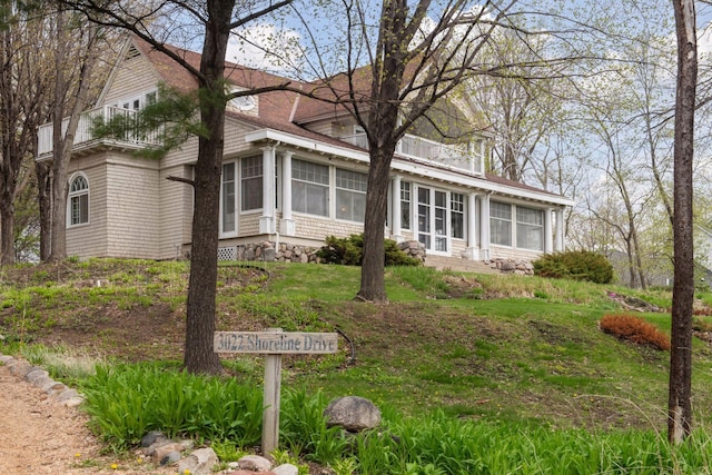 view of front facade with a sunroom and a balcony