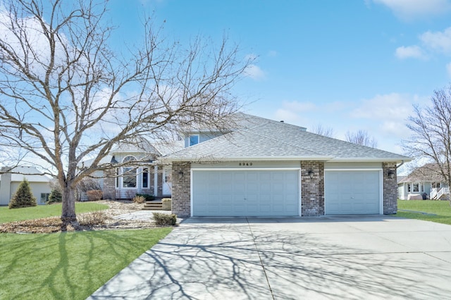 traditional-style home featuring an attached garage, concrete driveway, a shingled roof, a front lawn, and brick siding