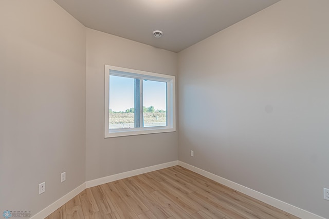 unfurnished room with light wood-style flooring and baseboards