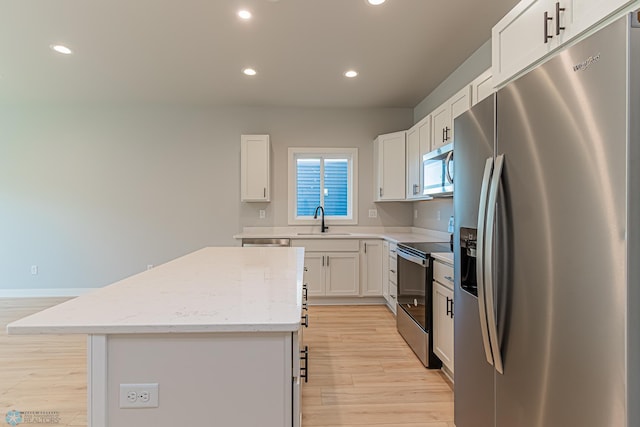 kitchen with recessed lighting, light wood-style flooring, appliances with stainless steel finishes, a sink, and a center island