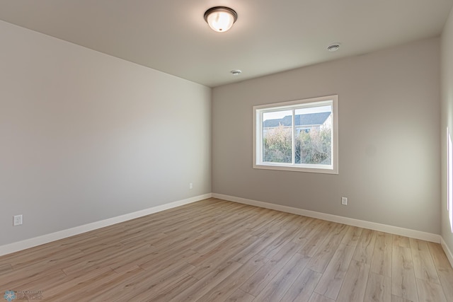 unfurnished room with baseboards and light wood finished floors