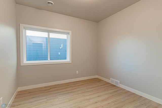 spare room with visible vents, baseboards, and light wood-style floors