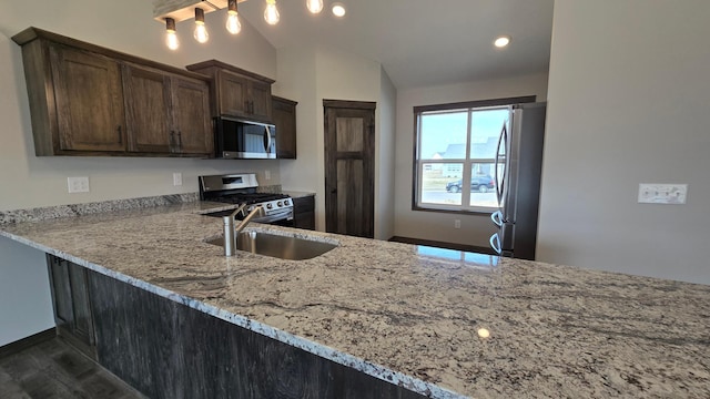 9972 14th Cir NE, Saint Michael, MN 55376 - kitchen with stainless steel appliances, light stone countertops, lofted ceiling, dark brown cabinets, and dark wood finished floors