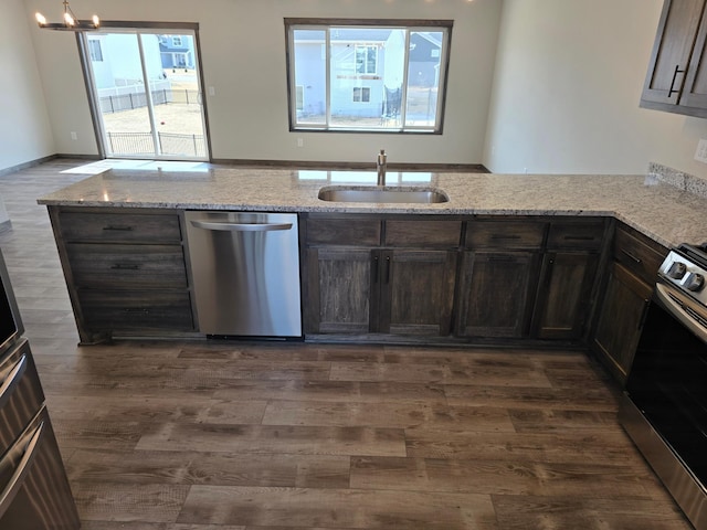 9972 14th Cir NE, Saint Michael, MN 55376 - kitchen featuring appliances with stainless steel finishes, light stone countertops, dark brown cabinetry, and dark wood-style flooring
