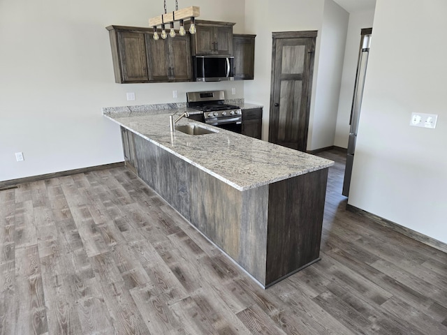 9972 14th Cir NE, Saint Michael, MN 55376 - kitchen featuring stainless steel appliances, light wood-style floors, dark brown cabinetry, light stone counters, and a peninsula