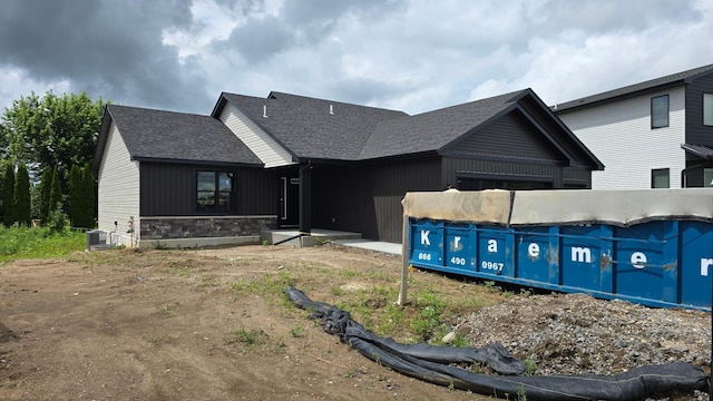 9972 14th Cir NE, Saint Michael, MN 55376 - view of front of home featuring a shingled roof, stone siding, a swimming pool, and board and batten siding