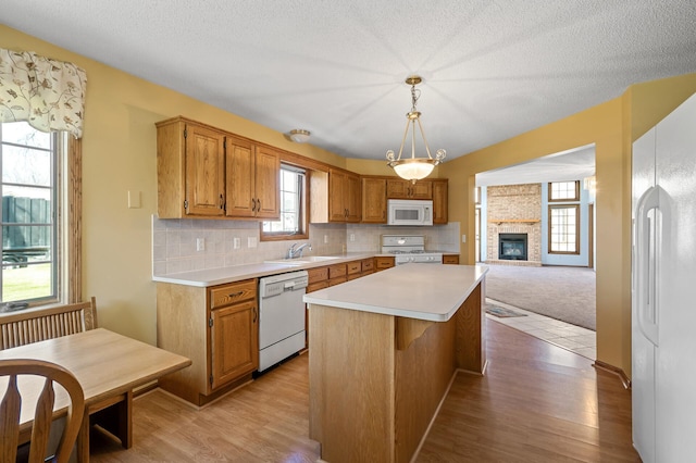 1904 Beebe Rd, Maplewood, MN 55109 - kitchen with white appliances, a sink, light countertops, a center island, and light wood finished floors