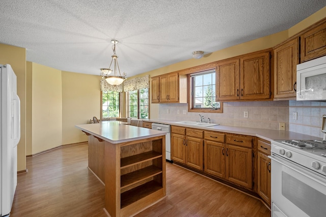 1904 Beebe Rd, Maplewood, MN 55109 - kitchen with white appliances, a sink, brown cabinetry, light wood-style flooring, and a textured ceiling