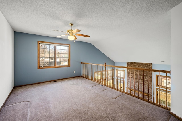 1904 Beebe Rd, Maplewood, MN 55109 - additional living space featuring a ceiling fan, carpet flooring, a textured ceiling, lofted ceiling, and baseboards