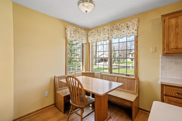 1904 Beebe Rd, Maplewood, MN 55109 - dining room with light wood-style flooring, baseboards, and a textured ceiling