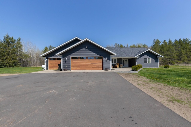 view of front of house featuring a front yard, an attached garage, and asphalt driveway