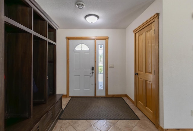 entryway with a textured ceiling and baseboards