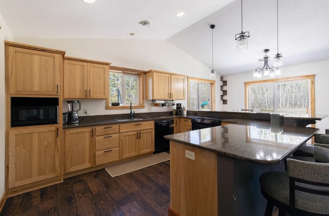 kitchen featuring a sink, vaulted ceiling, black appliances, a kitchen breakfast bar, and dark wood finished floors