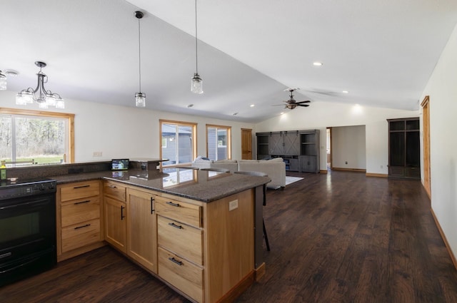 kitchen featuring black / electric stove, lofted ceiling, a ceiling fan, light brown cabinetry, and a kitchen breakfast bar