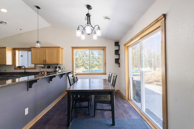 dining room with lofted ceiling, dark wood-style floors, a chandelier, and baseboards