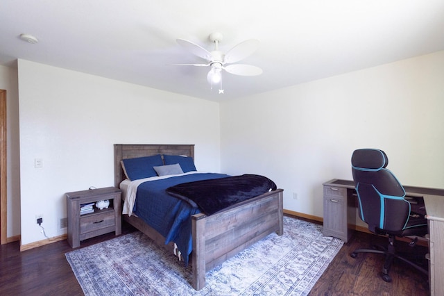 bedroom featuring wood finished floors, an office area, baseboards, and a ceiling fan