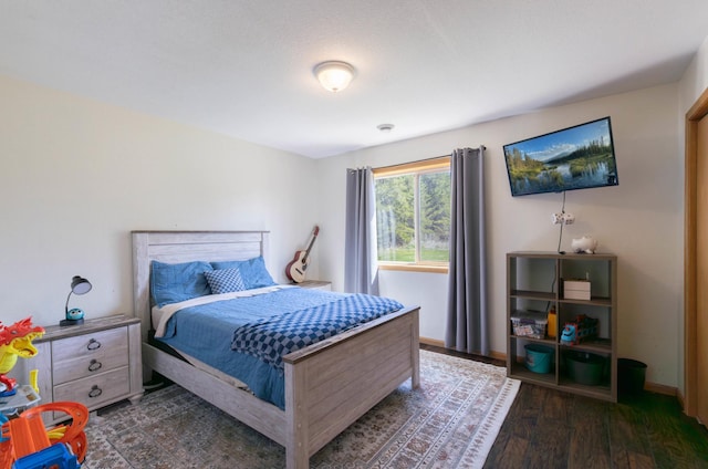bedroom with wood finished floors and baseboards
