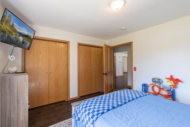 bedroom with multiple closets, dark wood finished floors, and baseboards