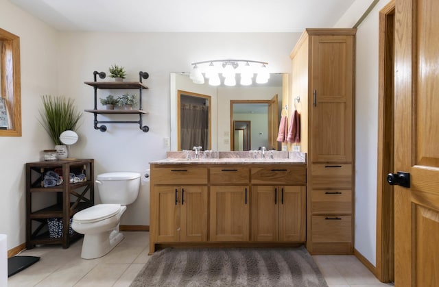 full bath with tile patterned flooring, toilet, baseboards, and double vanity
