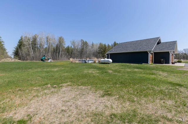 view of green lawn with a garage