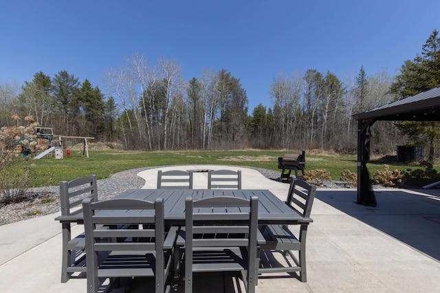 view of patio featuring a playground and outdoor dining area