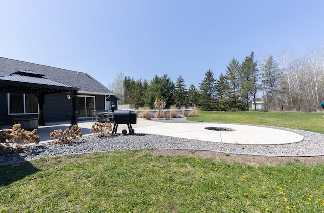 view of grassy yard featuring a gazebo, a patio, and an outdoor fire pit